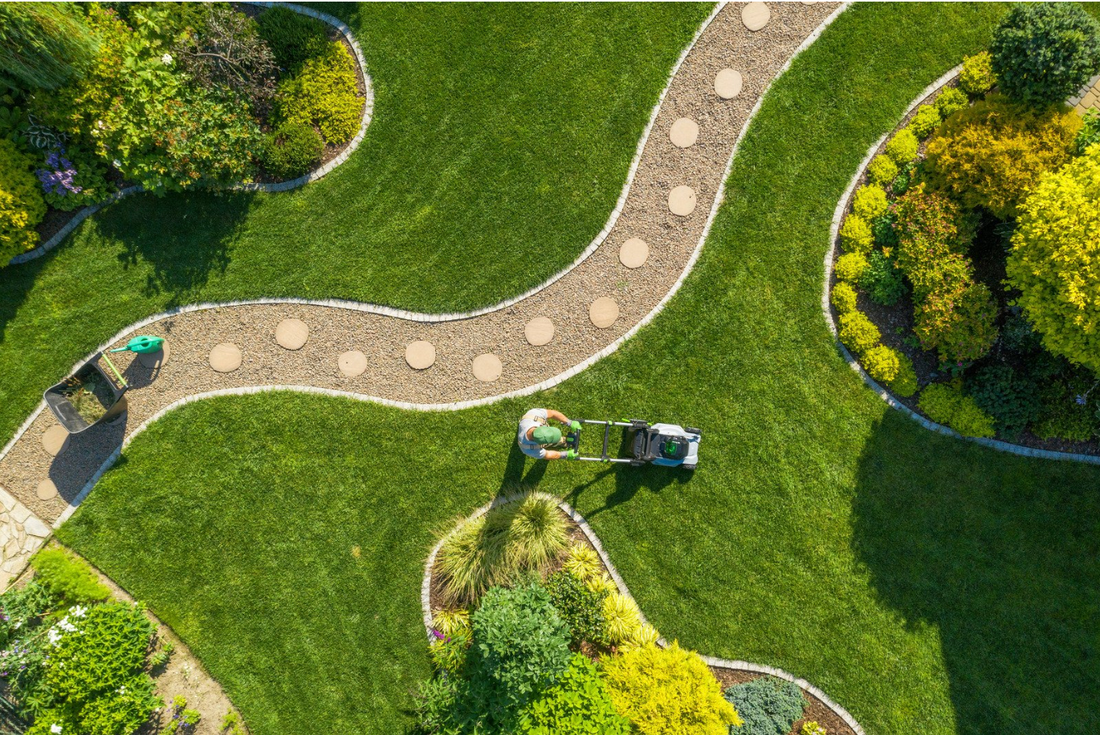 guy mowing grass of nice landscape area with ezy hex garden path